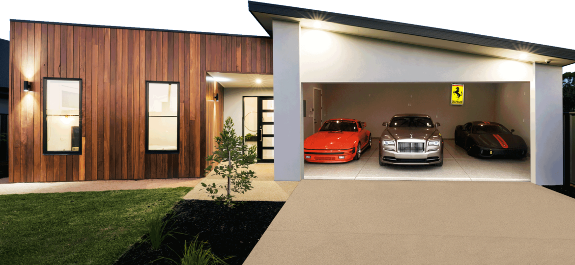 Modern home exterior at dusk with a wooden facade and warm lighting, featuring a driveway leading to an open garage showcasing three luxury cars: a bright orange sports car on the left, a silver luxury sedan in the center, and a black sports car on the right. A Ferrari logo is visible on the wall above the black car.