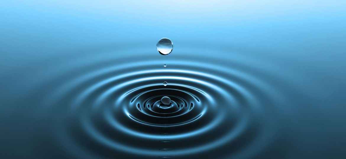 A serene image showcasing the tranquil beauty of water dynamics, with a single water droplet suspended above a body of water creating a series of concentric ripples, all captured against a gradient blue background, symbolizing purity, calmness, and the elegance of simplicity in nature.