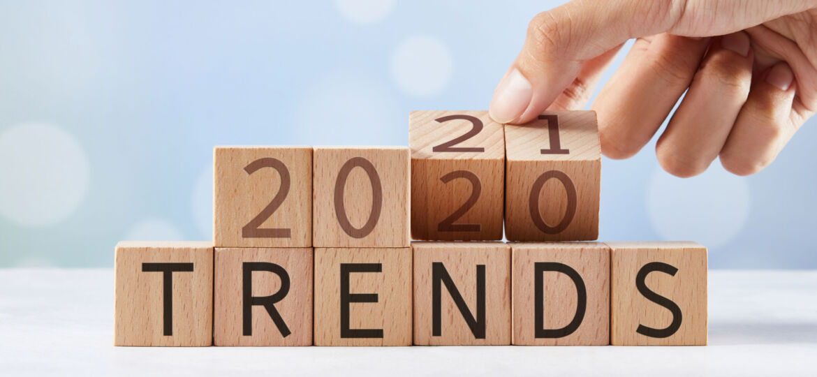 A hand stacking wooden blocks with the numbers 20, 20, and 21 on them, above the word 'TRENDS' spelled out on a lower row of blocks, representing the concept of building or following epoxy trends over the years.