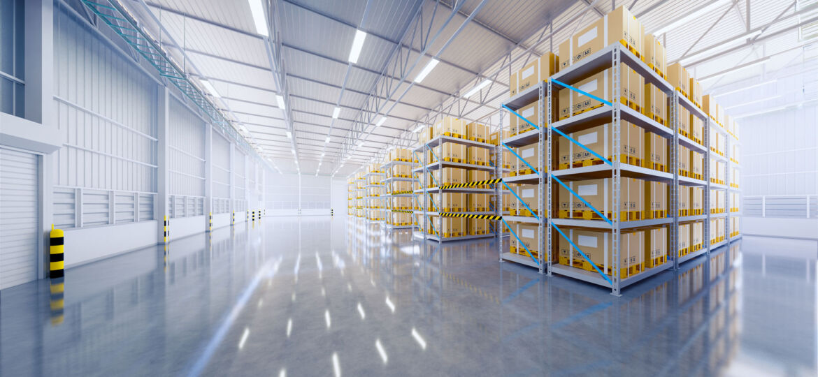 A spacious, well-lit warehouse interior with high ceilings, featuring rows of tall shelving units stocked with uniformly sized boxes, reflecting an organized storage and logistics environment.