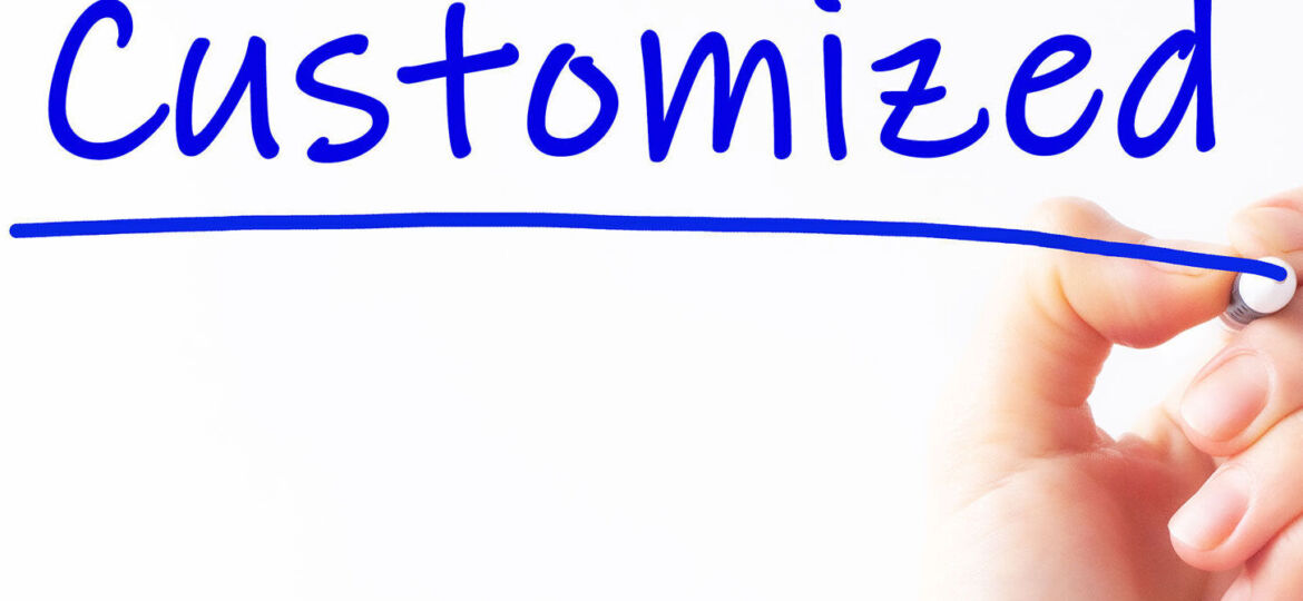 A hand holding a marker pen that has just finished writing the word 'Customized' in bold blue letters on a white background. The underline below the text suggests completion and emphasis on personalized epoxy coatings.