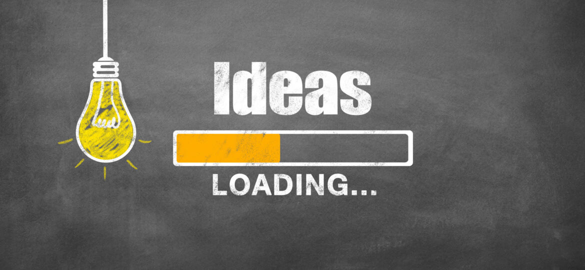 Conceptual image featuring a chalkboard with a graphic of a yellow light bulb and the word 'Ideas' written in white chalk. Next to the light bulb is a stylized loading bar with one segment filled in yellow, accompanied by the word 'LOADING...' indicating the process of thinking or coming up with ideas.